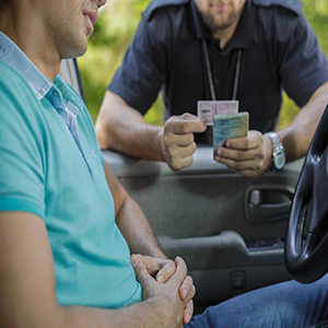 Georgia DUI License: Police officer checking a driver's license during a Georgia DUI traffic stop.
